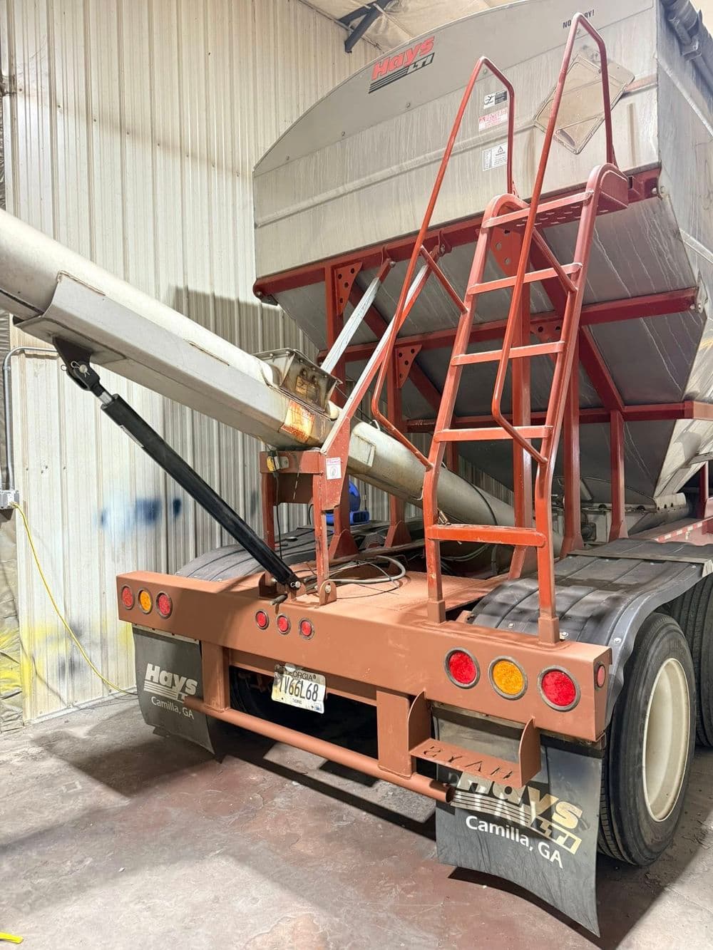 Hays truck trailer with unloading auger and ladder in a storage facility, Camilla, GA.