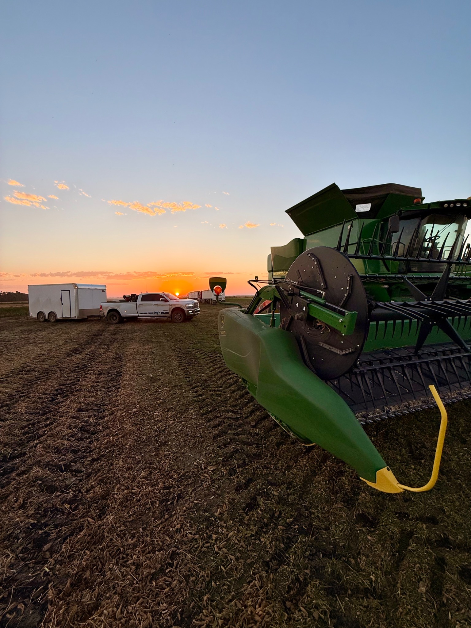 Oley's mobile welding truck and combine at sunset in the field